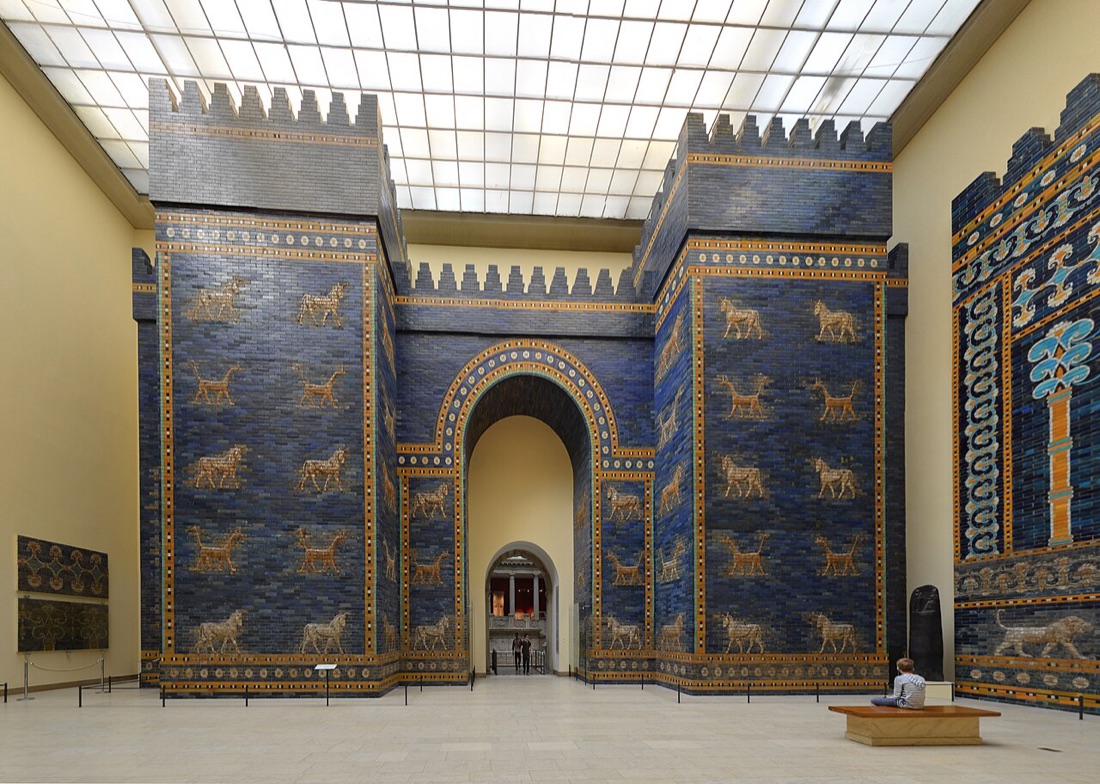 The Ishtar Gate, reconstructed from its excavated glazed brick in Berlin's Pergamon Museum — lapis-blue, with bulls and dragons in relief.